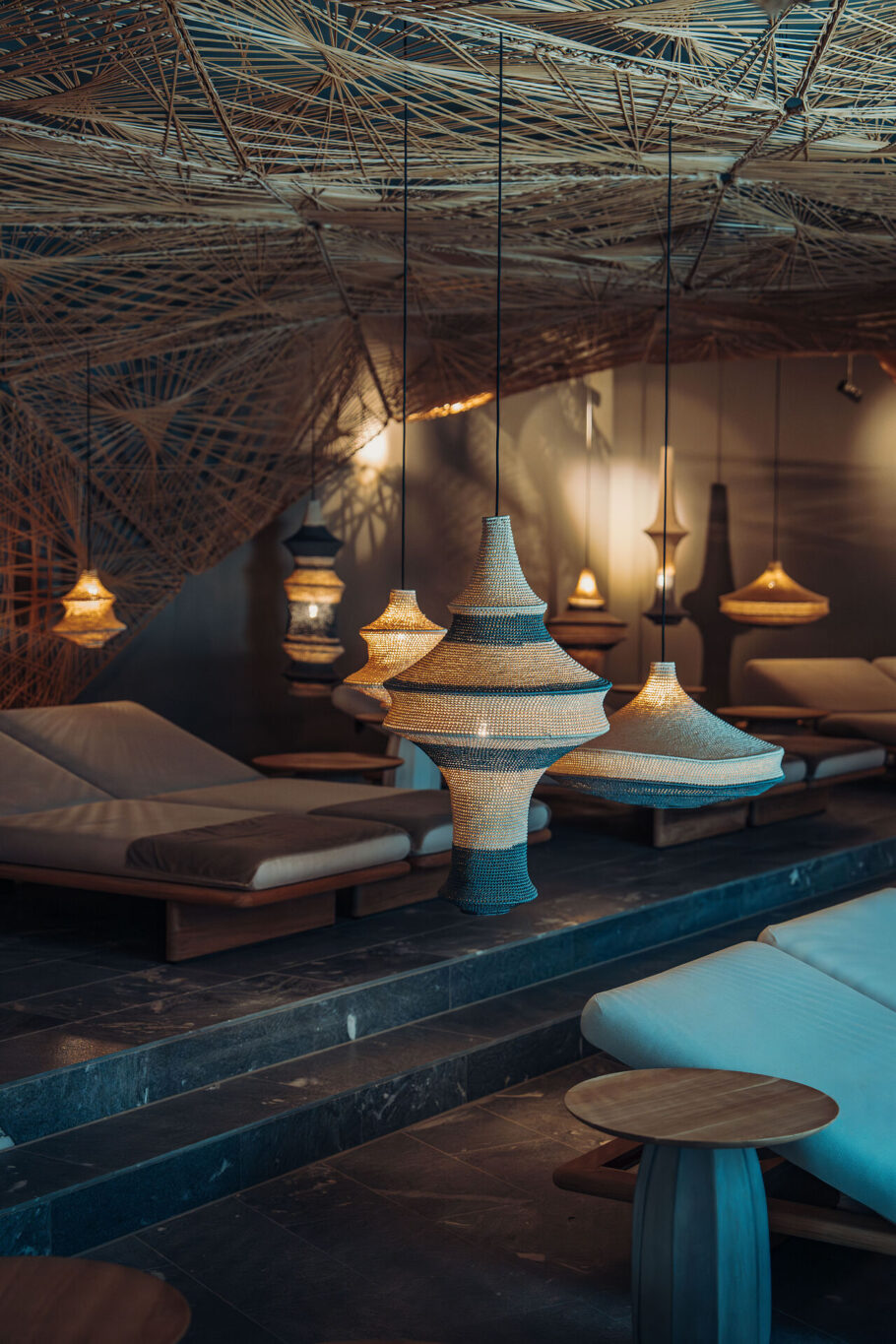 Liegebereich Atrium mit gepolsterten Liegen und Korbgeflecht an der Decke