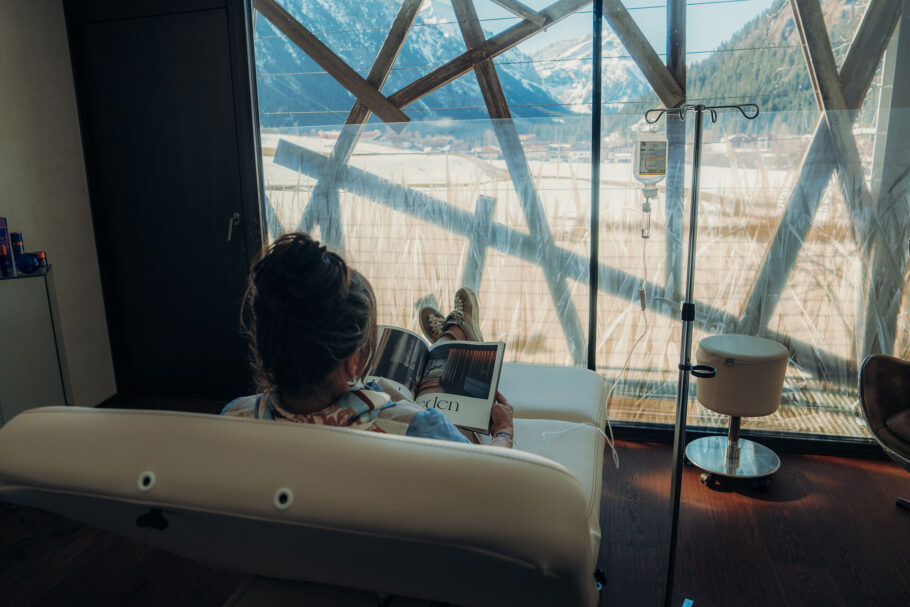 Gast bei der Infusionstherapie in der Anwendungskabine mit Ausblick in die Natur