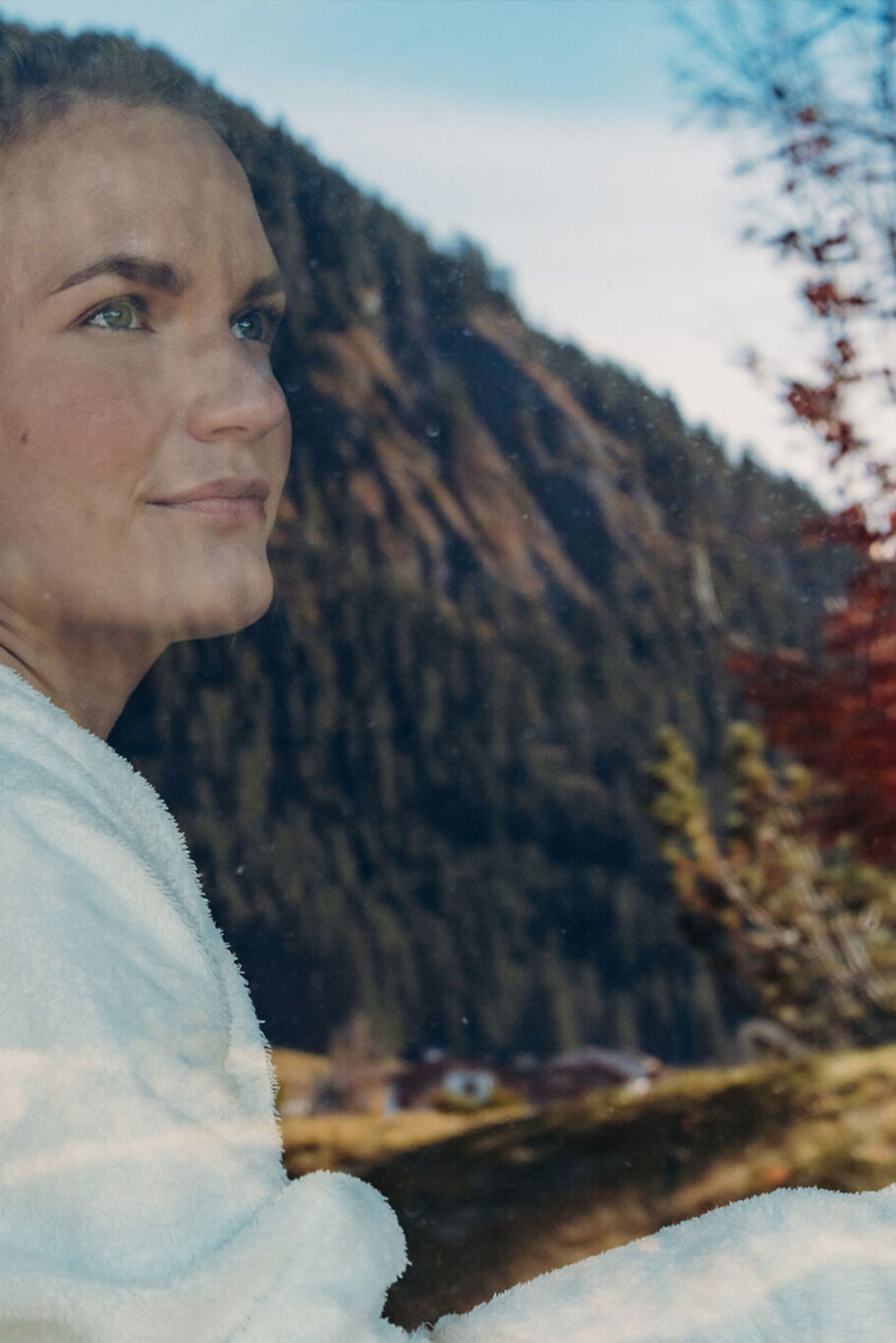 Frau in der 3D-Biopanoramasauna mit herbstlicher Spiegelung