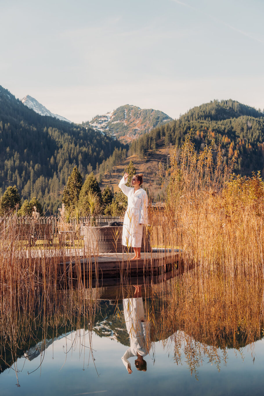 Frau am Naturteich zwischen Gräser im Jungbrunn