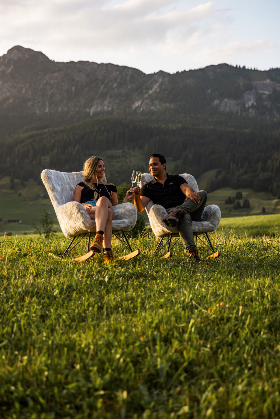 Pärchen auf der Wiese beim Anstoßen