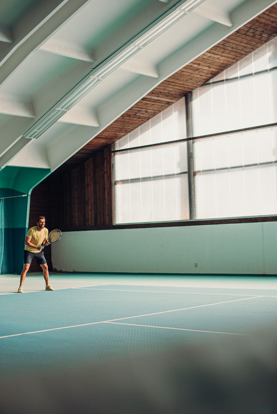 Mann beim Tennisspielen im Jungbrunn