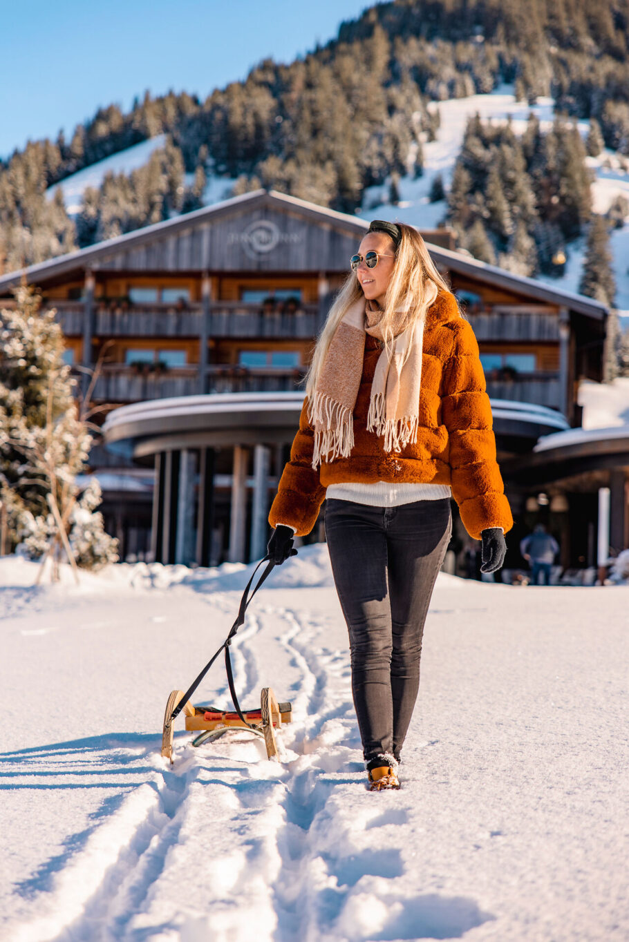 Frau mit Schlitten vor dem Hoteleingang des Jungbrunn